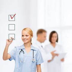 Image showing doctor or nurse drawing checkmark into checkbox