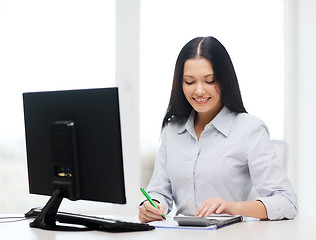 Image showing businesswoman or student working with calculator