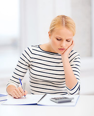 Image showing woman with notebook and calculator studying