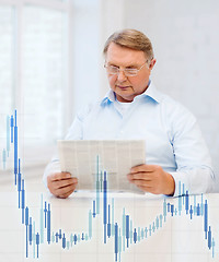 Image showing old man at home with newspaper and forex chart