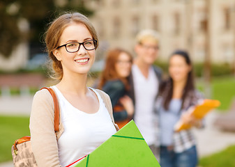 Image showing female student in eyglasses with folders