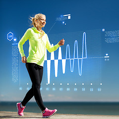 Image showing smiling woman doing sports outdoors with earphones