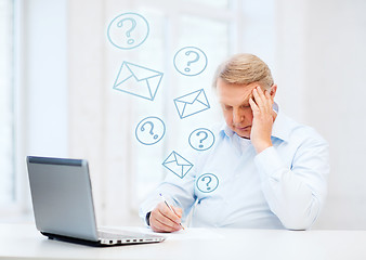 Image showing old man filling a form at home