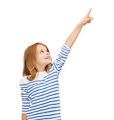 Image showing smiling girl pointing at virtual screen