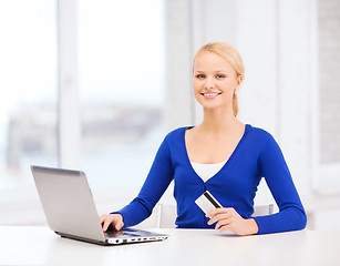 Image showing smiling woman with laptop computer and credit card