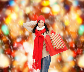 Image showing smiling woman in warm clothers with shopping bags