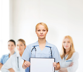 Image showing smiling female doctor or nurse with sclipboard