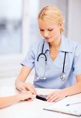 Image showing female doctor or nurse measuring blood sugar value