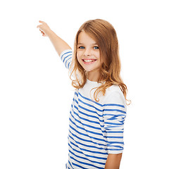 Image showing smiling girl pointing at virtual screen