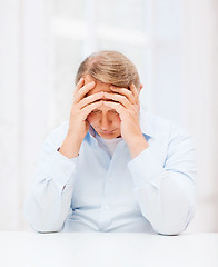 Image showing stressed old man holding head at home