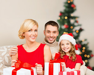 Image showing smiling family holding many gift boxes