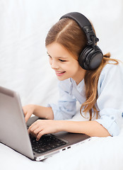 Image showing girl with laptop computer and headphones at home