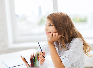 Image showing little student girl drawing and dreaming at school