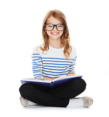 Image showing smiling little student girl sitting on the floor