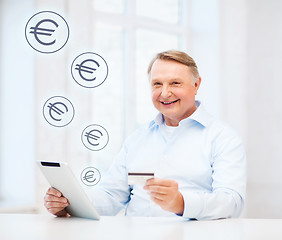 Image showing old man with tablet pc and credit card at home