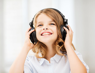 Image showing smiling little girl with headphones at home