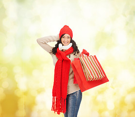 Image showing smiling woman in warm clothers with shopping bags