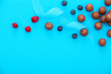 Image showing chocolate pralines and fresh berries