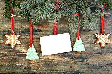 Image showing Card and Christmas cookies on fir branches.