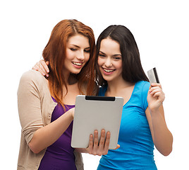 Image showing two smiling girls with tablet pc and credit card