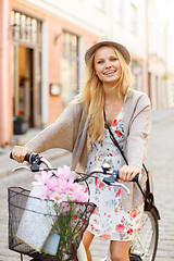 Image showing attractive woman in hat with bicycle in the city