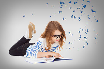 Image showing smiling little student girl lying on the floor