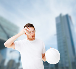 Image showing male architect in safety glasses taking off helmet