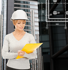 Image showing female contractor in white helmet with files