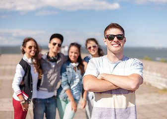 Image showing teenage boy with sunglasses and friends outside