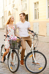 Image showing smiling couple with bicycles in the city