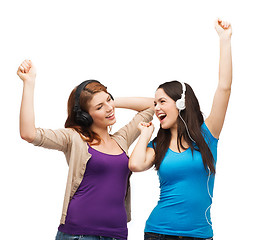 Image showing two laughing girls with headphones dancing