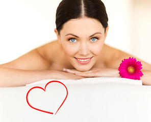 Image showing smiling woman with flower in spa salon
