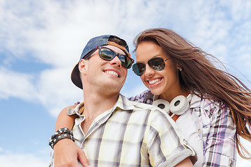 Image showing smiling teenagers in sunglasses having fun outside