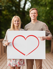 Image showing romantic couple with white board and heart on it