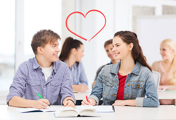 Image showing two teenagers with notebooks and book at school