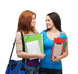 Image showing two smiling students with bag and folders