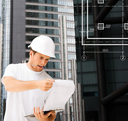 Image showing male architect in helmet looking at blueprint
