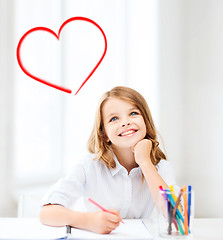 Image showing smiling little student girl drawing at school