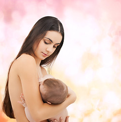 Image showing happy mother feeding her adorable baby