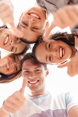 Image showing group of smiling teenagers looking down