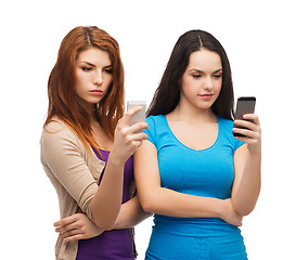 Image showing two serious teenagers with smartphones