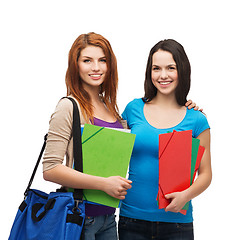 Image showing two smiling students with bag and folders