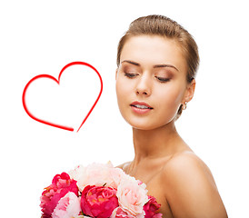 Image showing woman wearing earrings and holding flowers