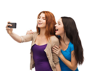 Image showing two smiling teenagers with smartphone