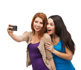 Image showing two smiling teenagers with smartphone