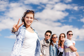 Image showing teenage girl with headphones and friends outside