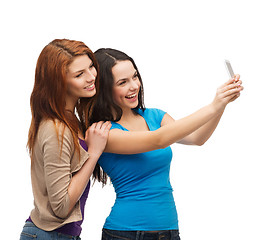 Image showing two smiling teenagers with smartphone