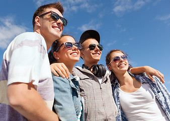 Image showing smiling teenagers in sunglasses hanging outside