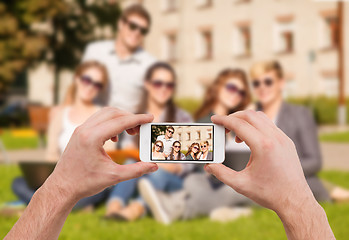 Image showing close up of hands making picture of group of teens