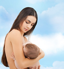 Image showing happy mother feeding her adorable baby